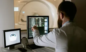 "a man reviewing data on his computer within a lab setting"