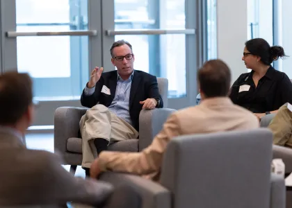 "male panelist speaking to a moderator"